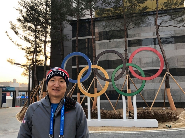 Man standing in front of Olympic rings